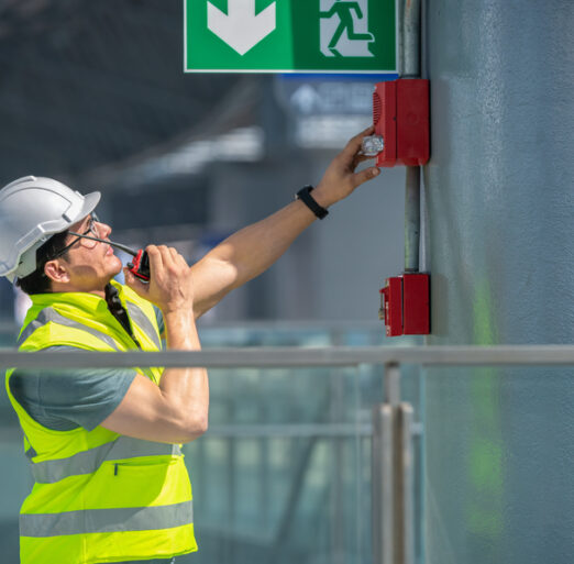Engineer,Wearing,Safety,Unifrom,And,Helmet,Under,Checking,Fire,Alarm